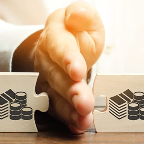 Businessman,Separates,The,Wooden,Puzzle,With,A,Picture,Of,Money. Businessman separates the wooden puzzle with a picture of money. The concept of financial management and distribution of funds. Saving and investing. Property division. Divorce and legal services